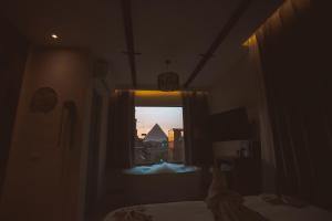 a bedroom with a window with a view of a pyramid at Pharaohs Land Hotel in Cairo