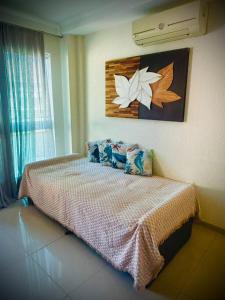 a bedroom with a bed with a painting on the wall at Summer Beach 300 mt da praia com amplo lazer e mobília nova in Bombinhas +23 photos
