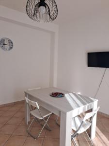 a white table with two chairs and a plate on it at La Piuma in Misterbianco