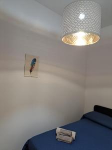 a bedroom with a blue bed and a light at La Piuma in Misterbianco