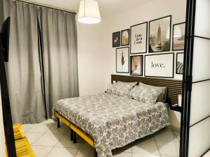 a bedroom with a bed and some pictures on the wall at Casa André Imola in Imola