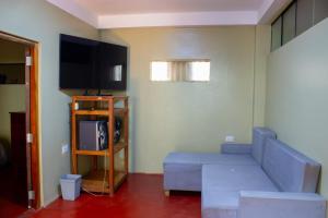 a living room with a couch and a flat screen tv at Posada del Carmen 2 in Quillabamba +3 photos