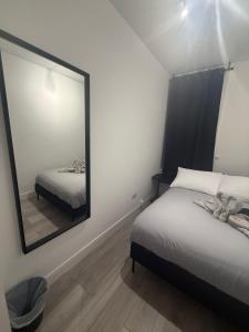 a bedroom with two beds and a large mirror at Balham in London