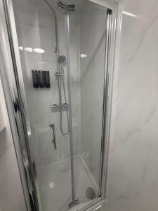 a shower with a glass door in a bathroom at Balham in London +3 photos
