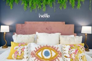 a bed with pillows and a hello sign on a wall at Moroccan Desert Oasis -Salt Pool - Spa - Games in Bermuda Dunes