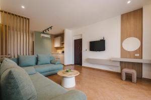 a living room with a blue couch and a tv at Apartments Kan in Ulcinj