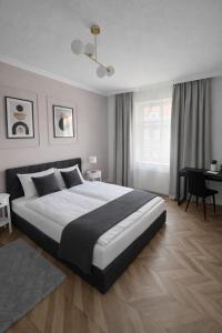 a bedroom with a large bed and a desk at PIASKI 4 - Boutique stay in Gdańsk