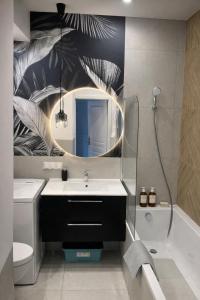 a bathroom with a sink and a mirror and a tub at PIASKI 4 - Boutique stay in Gdańsk +14 photos