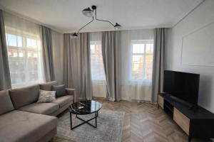 a living room with a couch and a flat screen tv at PIASKI 4 - Boutique stay in Gdańsk