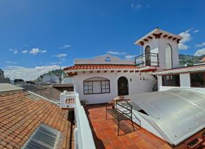 a white house with a roof with a balcony at Casa Lucía Hotel by Las Plazas in Quito