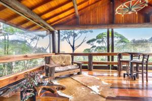 a living room with a table and chairs on a porch at Pousada Parador 33 in Biguaçu