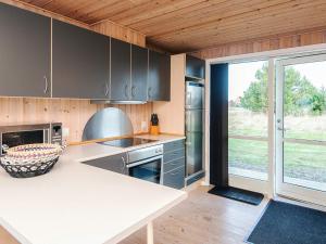 a kitchen with a counter top and a large window at 4 star holiday home in Ulfborg in Fjand Gårde