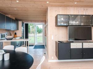 a kitchen with wooden walls and a black counter top at 4 star holiday home in Ulfborg in Fjand Gårde