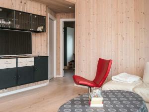 a living room with a red chair and a couch at 4 star holiday home in Ulfborg in Fjand Gårde +35 photos