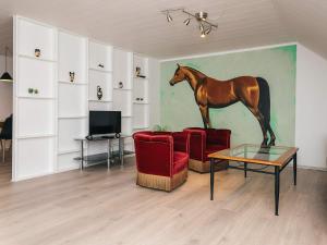 a living room with a painting of a horse on the wall at Charming Retreat in Ringkobing in Ringkøbing