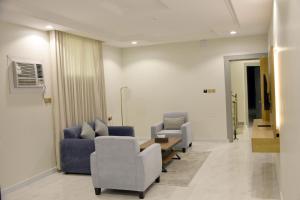a waiting room with couches and a table and chairs at غيمة in Hail