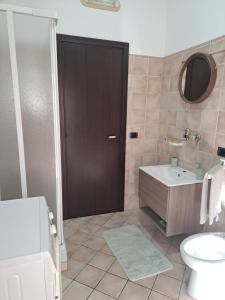 a bathroom with a toilet and a sink and a door at La Piuma in Misterbianco +7 photos