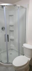 a bathroom with a shower with a toilet and a sink at Pells Hostel in Regina +33 photos