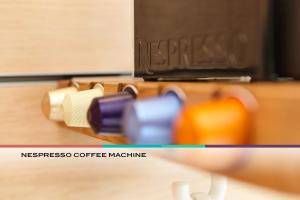 a close up of a coffee machine with different colored cups at Steinenschanze Stadthotel in Basel