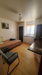 a room with two beds and a chair and a table at Pells Hostel in Regina