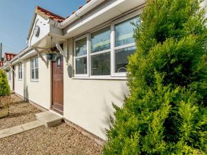 a white house with a tree in front of it at 2 Bed in Louth oc-86797 in Louth
