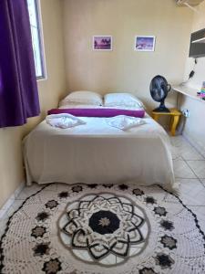 a bedroom with two beds and a rug at Studio Funcional in Guaraqueçaba