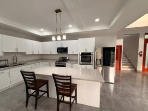 a kitchen with two chairs and a large white counter at MeMe's Place in Placencia