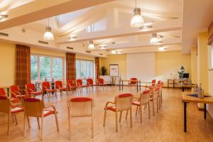 a large room with chairs and tables and a podium at Hotel Backenköhler in Ganderkesee