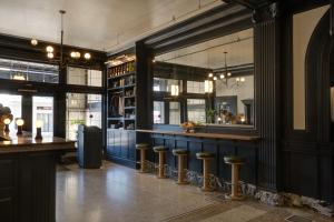 a restaurant with a bar with stools in a room at MarQueen Hotel - NEWLY RENOVATED in Seattle