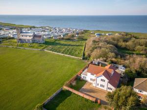 an aerial view of a house and the ocean at 4 Bed in Cromer oc-81469 in West Runton