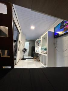 a room with a bed and a tv on a wall at Loft fundos shopping Catuai e lago in Cascavel