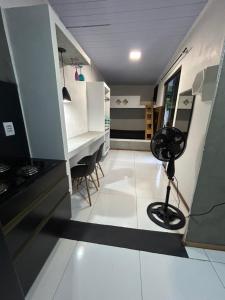 a room with a white floor and a desk with a fan at Loft fundos shopping Catuai e lago in Cascavel