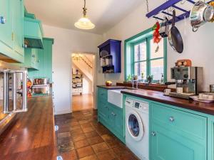 a kitchen with blue cabinets and a washer and dryer at 3 Bed in Holt oc-87147 in Holt