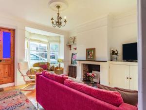 a living room with a red couch and a fireplace at 3 Bed in Holt oc-87147 in Holt