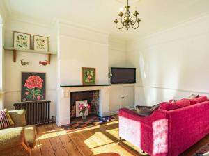 a living room with a red couch and a fireplace at 3 Bed in Holt oc-87147 in Holt +6 photos
