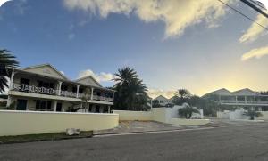 a street in front of a building with palm trees at The Palms apt 1 in Cedar Grove