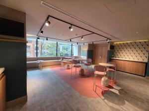 a room with tables and chairs and a large window at Novotel Bogota Parque 93 in Bogotá