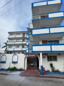a tall building with a blue and white building at Acapulco LUUM hotel in Acapulco