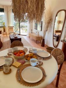 a table with plates and bowls of fruit on it at Seren Casa Begur - Illa Roja Beach in Begur