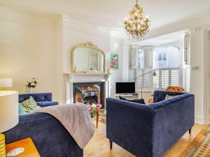 a living room with two blue chairs and a fireplace at 4 Bed in Holt oc-87148 in Holt