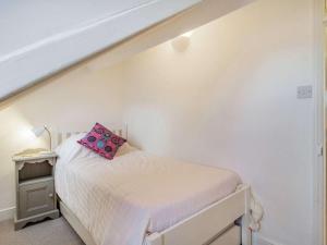 a bedroom with a bed with a pink pillow on it at 4 Bed in Holt oc-87148 in Holt