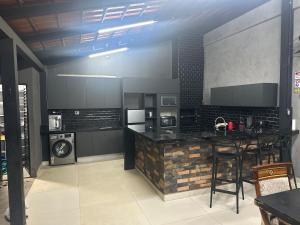 a kitchen with black cabinets and a bar with chairs at Espaço Atlântico in Goiânia