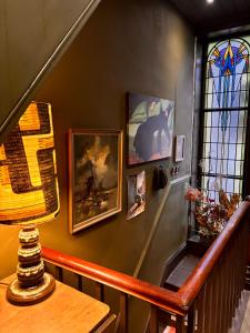 a room with a wall with paintings and a table at The Goose Garden in Hebden Bridge
