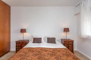 a bedroom with a bed with two night stands and two lamps at Lisbon at Home in Lisbon +11 photos