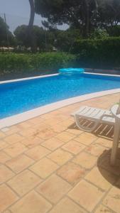 a white chair sitting next to a swimming pool at Lisbon at Home in Lisbon