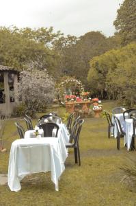 a group of tables and chairs with white table cloth at Sítio Conquista Feliz in Nova Iguaçu