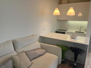 a living room with a couch and a kitchen at Casa do Cuco in Esposende