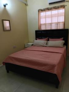 a bedroom with a large bed with a red bedspread at Southern Haven Guesthouse in Laborie