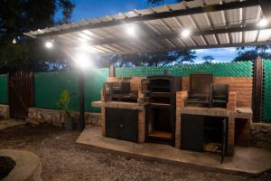 a patio with an outdoor kitchen under a pergola at Refugio Lagunas in San Antonio