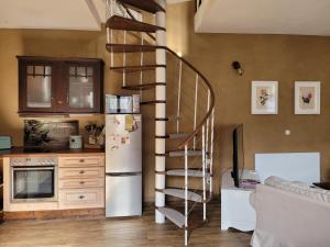 a kitchen with a spiral staircase next to a refrigerator at Romantisches Rosencottage in Hofheim in Unterfranken +6 photos